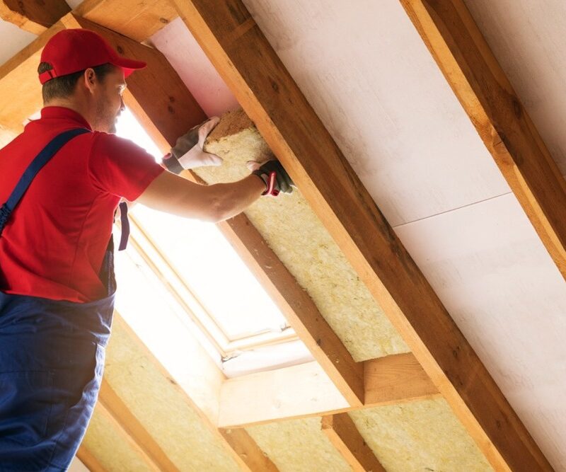 Technician installing blown-in attic insulation in Owen Sound home.